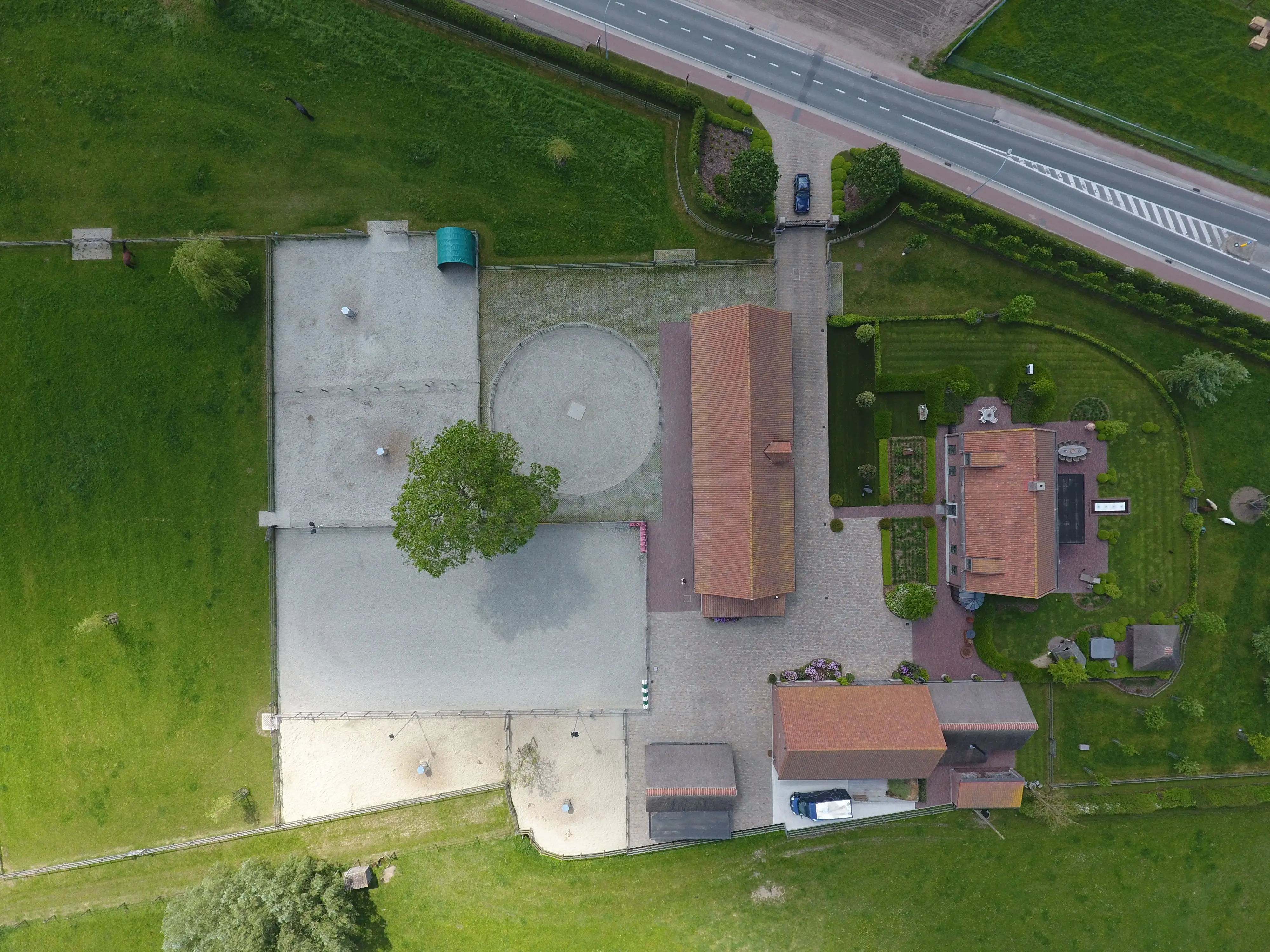 Luchtfoto van de pistes, longeercirkel en gebouwen